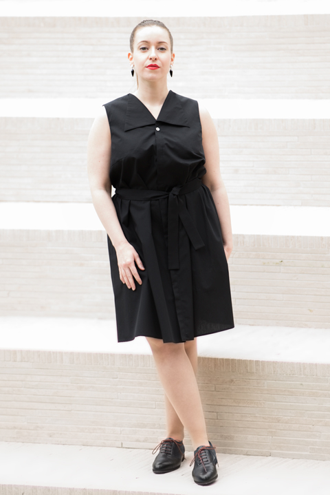 ärmelloses Sommerkleid mit konstruktivistischem Kragen, verdeckter Knopfleiste und Bindegürtel aus schwarzer Bio-Baumwolle